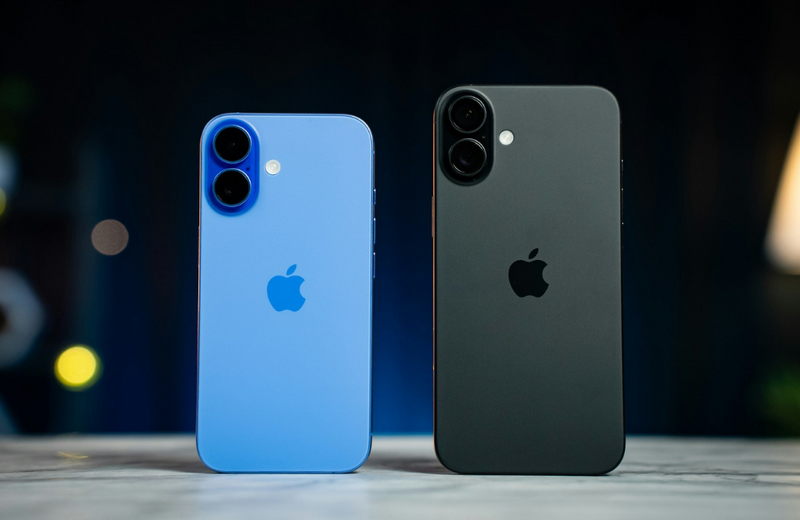 A blue iPhone 16 and a black iPhone 16 Plus standing up side by side with the back of the phone facing the camera. 