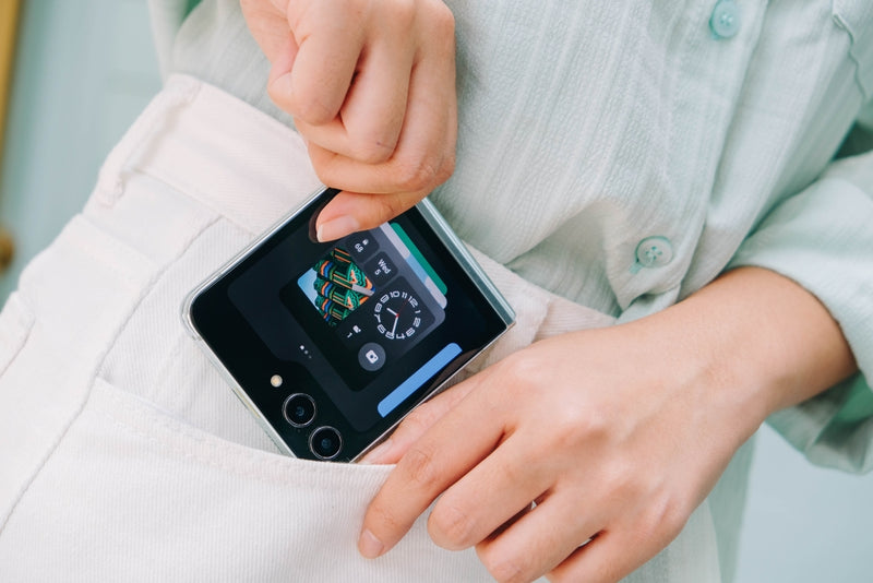 A woman putting A Samsung Z Flip in her pocket