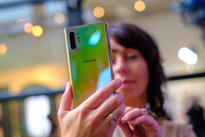 Woman holding green Samsung Note 10 phone