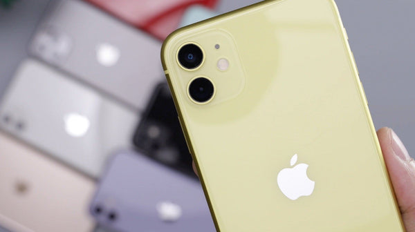 A pastel yellow iPhone with other iPhones out of focus in the background