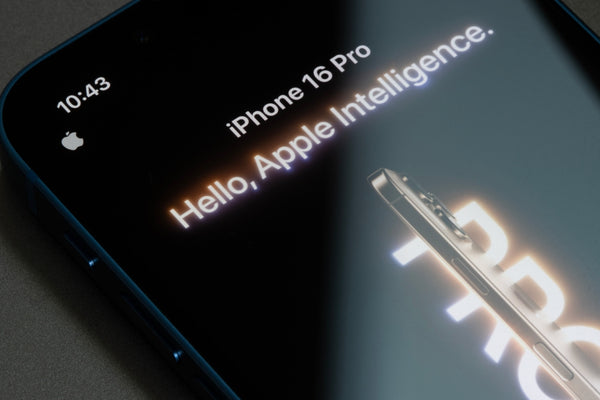 A close up of the top of an iPhone saying "Hello, Apple Intelligence" on the screen. 